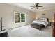 Bright bedroom features soft carpet, a large window, ceiling fan, and neutral paint at 580 Cliftwood Ct, Sandy Springs, GA 30328
