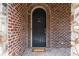 Elegant black front door with decorative hardware, set within a brick and stone facade, offers a grand entrance at 580 Cliftwood Ct, Sandy Springs, GA 30328