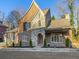 Charming brick and stone home featuring an arched entryway, manicured landscaping, and a classic architectural design at 580 Cliftwood Ct, Sandy Springs, GA 30328