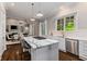 The modern kitchen offers stainless appliances, white cabinets, marble countertops, island, and view of the dining room at 580 Cliftwood Ct, Sandy Springs, GA 30328