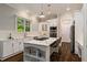 Bright kitchen boasts white cabinetry, stainless appliances, marble countertops, and a functional center island at 580 Cliftwood Ct, Sandy Springs, GA 30328