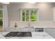 Updated kitchen features white cabinets, marble countertops, tile backsplash, stainless appliances, and natural light at 580 Cliftwood Ct, Sandy Springs, GA 30328