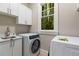 Convenient laundry room with modern washer, dryer, sink, and white cabinets at 580 Cliftwood Ct, Sandy Springs, GA 30328