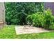 Exterior stone patio with seating, a table, lawn, mature plantings, and privacy at 580 Cliftwood Ct, Sandy Springs, GA 30328