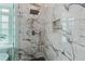 A stunning shower with marble tile, a rainfall shower head and a built-in niche for toiletries at 580 Cliftwood Ct, Sandy Springs, GA 30328