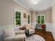 Inviting sitting room featuring a hardwood floor, two armchairs, and three windows with a wooded view at 580 Cliftwood Ct, Sandy Springs, GA 30328