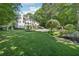 Lovely backyard featuring a well-manicured lawn, beautiful landscaping, an inground pool, and an elegant home exterior at 1240 Bridgewater Walk, Snellville, GA 30078