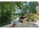 Beautifully landscaped backyard featuring lush greenery, a patio, and serene views of the lake at 1240 Bridgewater Walk, Snellville, GA 30078