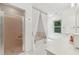 Bright bathroom featuring a glass-enclosed shower, soaking tub with curtains, and a modern vanity at 1240 Bridgewater Walk, Snellville, GA 30078