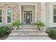 Charming stone entrance featuring decorative plants, stone steps, and stylish front door with glass detail at 1240 Bridgewater Walk, Snellville, GA 30078