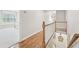 Upstairs hallway with wood floors that offer a view of a bedroom with a window seat at 1240 Bridgewater Walk, Snellville, GA 30078