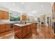 Spacious open kitchen with wood cabinets, island, and adjoining dining area with stone fireplace at 1240 Bridgewater Walk, Snellville, GA 30078