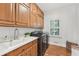 Well-equipped laundry room with cabinetry, sink, stainless steel washer and dryer at 1240 Bridgewater Walk, Snellville, GA 30078