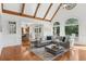 Sunlit living room featuring hardwood floors, high ceilings, and large windows overlooking the backyard and kitchen at 1240 Bridgewater Walk, Snellville, GA 30078