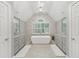 Beautiful bathroom with dual vanities, soaking tub, statement wall, and arched window at 1240 Bridgewater Walk, Snellville, GA 30078