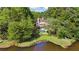 Beautiful rear exterior view of home featuring a pool, lush landscaping, lakeside, and a private retreat at 1240 Bridgewater Walk, Snellville, GA 30078