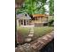 Manicured backyard featuring a shed, pergola, stone walls, and a brick path at 2320 Glynmoore Dr, Lawrenceville, GA 30043