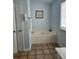 A pristine bathroom featuring a soaking tub, tile floors, and calming light blue walls at 2320 Glynmoore Dr, Lawrenceville, GA 30043