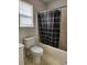 Standard bathroom featuring a toilet, bathtub with a shower curtain, and window at 2320 Glynmoore Dr, Lawrenceville, GA 30043