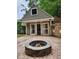Outdoor brick patio with a small storage house featuring double French doors with a stone fire pit at 2320 Glynmoore Dr, Lawrenceville, GA 30043