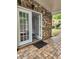 Covered outdoor patio with access to the interior of home and landscaped yard with brick features at 2320 Glynmoore Dr, Lawrenceville, GA 30043