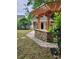 Backyard area with a wooden pergola, stone walls, green shed and brick design at 2320 Glynmoore Dr, Lawrenceville, GA 30043