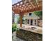 Backyard area with a wooden pergola, stone walls, and outdoor space for relaxation at 2320 Glynmoore Dr, Lawrenceville, GA 30043