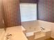 A white bath tub, sink, and wallpapered walls make for a nice bathroom at 775 Brand South Trl, Lawrenceville, GA 30046