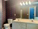 A bathroom with a double sink, wallpaper, a toilet, and a white vanity at 775 Brand South Trl, Lawrenceville, GA 30046