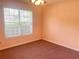 Bedroom with light orange walls, pink carpet, a window, and ceiling fan at 775 Brand South Trl, Lawrenceville, GA 30046