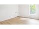 Empty bedroom with large windows, a closet, white walls, and light wood floors at 104 Meldon Ave, Atlanta, GA 30315