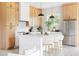 Bright kitchen with white countertops, an island with seating, modern appliances, and natural wood cabinets at 104 Meldon Ave, Atlanta, GA 30315