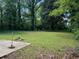 Grassy backyard with a concrete slab, ideal for outdoor seating and entertaining at 3127 Latona Sw Dr, Atlanta, GA 30354