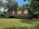 Traditional single-story home featuring mixed siding, brick details, and mature trees at 3127 Latona Sw Dr, Atlanta, GA 30354