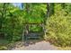 A wooden swing set is situated in the peaceful woods behind the home at 415 Stephanie Ct, Stockbridge, GA 30281