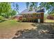 Large backyard with mature trees, a wooden deck, and a brick home exterior at 415 Stephanie Ct, Stockbridge, GA 30281
