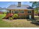 Cozy brick home featuring a covered porch and a well-maintained lawn and garden at 415 Stephanie Ct, Stockbridge, GA 30281