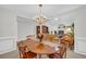Open concept dining room with wood table, decorative chandelier and view into the living room and fireplace at 415 Stephanie Ct, Stockbridge, GA 30281