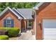 Close-up of brick facade with an ornate light fixture and neatly trimmed landscaping at 415 Stephanie Ct, Stockbridge, GA 30281
