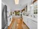 Bright kitchen features white cabinets, long countertops, modern appliances, a window and decorative runner at 415 Stephanie Ct, Stockbridge, GA 30281