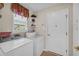 Practical laundry room with modern washer and dryer and shelving above at 415 Stephanie Ct, Stockbridge, GA 30281