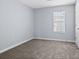 Bedroom with gray carpet, a window with blinds, and a white door at 740 Marcus Nyah Ct, Atlanta, GA 30349