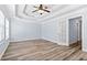 Bright bedroom features a tray ceiling, wood floors and a door leading to other rooms at 740 Marcus Nyah Ct, Atlanta, GA 30349