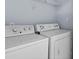 Functional laundry room with washer, dryer, and shelf at 740 Marcus Nyah Ct, Atlanta, GA 30349