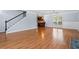 Hardwood living room features stairs and a view of kitchen with breakfast bar at 740 Marcus Nyah Ct, Atlanta, GA 30349