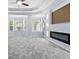A large main bedroom with neutral paint has a modern fireplace and several large windows at 740 Marcus Nyah Ct, Atlanta, GA 30349