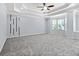 A bright main bedroom has neutral walls, gray carpeting, and a tray ceiling at 740 Marcus Nyah Ct, Atlanta, GA 30349
