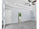 A bright main bedroom with a modern fireplace, tray ceiling, and a hallway at 740 Marcus Nyah Ct, Atlanta, GA 30349