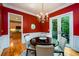 This dining room has red walls, chandelier, and a door to the outside at 10090 Jones Bridge Rd # 2, Alpharetta, GA 30022