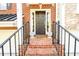 Inviting brick front entrance with a black door, decorative plants, and iron railings at 10090 Jones Bridge Rd # 2, Alpharetta, GA 30022